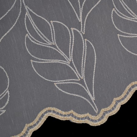 Zbliżenie na haft firany - motyw liści ze złotą nitką na podkładzie z markizety. Detal wykończenia falą.