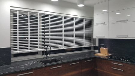 Wewnętrzne żaluzje drewniane w kolorze białym do kuchni.