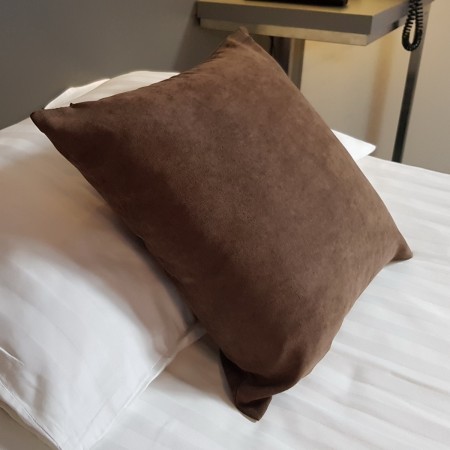 Poszewka dekoracyjna w kolorze brązowym.